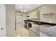 Galley kitchen with green cabinetry, black appliances, granite countertops and tile floor at 8400 Majestic View Ave, Las Vegas, NV 89129