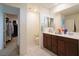 Well-lit bathroom featuring double vanities and a doorway leading to a walk-in closet at 8432 Alder Rain St, Las Vegas, NV 89113