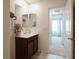 Bright bathroom with a dark vanity and an open doorway with a view into another room at 8432 Alder Rain St, Las Vegas, NV 89113