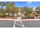 Well-maintained condo exterior featuring mature trees, desert landscaping, and a charming outdoor seating area at 8805 Jeffreys St # 2082, Las Vegas, NV 89123