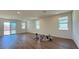 Open-concept living room with wood-look floors, abundant natural light, and sliding glass door leading to the backyard at 9067 Mapledale Ranch Ct, Las Vegas, NV 89139