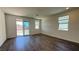 An open living room with wood flooring, natural light, and backyard access at 9067 Mapledale Ranch Ct, Las Vegas, NV 89139
