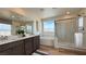 Bright bathroom featuring double sinks, soaking tub, and glass enclosed shower offering natural light and modern fixtures at 9190 Oakdale Ranch Ct, Las Vegas, NV 89139