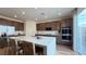 Modern kitchen with island seating, stainless appliances, hardwood floors, and stylish brown cabinets at 9190 Oakdale Ranch Ct, Las Vegas, NV 89139