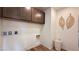 Convenient laundry room with upper cabinets and essential hookups, creating a functional and organized space at 9190 Oakdale Ranch Ct, Las Vegas, NV 89139