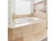 Close up shot of luxurious primary bathroom soaking tub with tile surround at 10227 Sunset Gardens Dr, Las Vegas, NV 89135