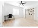 Bright bedroom with modern light fixture, built-in wall decor, desk, and light wood floors at 10227 Sunset Gardens Dr, Las Vegas, NV 89135