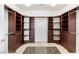 A spacious walk-in closet features custom wood shelving and cabinetry with granite flooring at 10227 Sunset Gardens Dr, Las Vegas, NV 89135