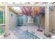 View of the front courtyard featuring a lovely shade tree and wrought iron entry gate at 10227 Sunset Gardens Dr, Las Vegas, NV 89135