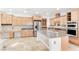 Spacious kitchen with stainless appliances, light wood cabinets, and island at 10227 Sunset Gardens Dr, Las Vegas, NV 89135
