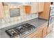 Kitchen features stainless steel gas cooktop, light wood cabinets, and tiled backsplash at 10227 Sunset Gardens Dr, Las Vegas, NV 89135