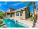 Backyard featuring a refreshing pool surrounded by lush landscaping and a covered patio at 10227 Sunset Gardens Dr, Las Vegas, NV 89135