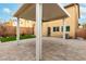 Covered patio in backyard with stone pavers, manicured grass, and desert landscaping at 10805 Knickerbocker Ave, Las Vegas, NV 89166