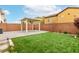 Backyard featuring artificial grass, a covered patio, and brick perimeter walls at 10805 Knickerbocker Ave, Las Vegas, NV 89166