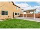 Backyard with grass, a covered patio with ceiling fan, and privacy fencing at 10805 Knickerbocker Ave, Las Vegas, NV 89166