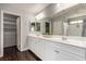 Bathroom with double sinks, vanity, large mirrors, and storage cabinets at 10805 Knickerbocker Ave, Las Vegas, NV 89166