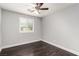 Bedroom with a ceiling fan, hardwood floors, white trim, and a window at 10805 Knickerbocker Ave, Las Vegas, NV 89166