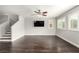 Spacious living room with wood floors, ceiling fan, large windows, and a staircase at 10805 Knickerbocker Ave, Las Vegas, NV 89166