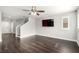 Open-concept living room with hardwood flooring, stairs, and large windows for ample natural light at 10805 Knickerbocker Ave, Las Vegas, NV 89166