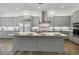 Modern kitchen boasts gray cabinets, stainless steel appliances, pendant lighting, and a large island at 11181 Luna Blanca Dr, Las Vegas, NV 89138