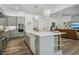 Well-lit kitchen with gray cabinets, stainless steel appliances, a large island, and open concept to living area at 11181 Luna Blanca Dr, Las Vegas, NV 89138