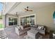 Covered patio with comfortable outdoor seating, ceiling fans, and sliding glass doors at 11181 Luna Blanca Dr, Las Vegas, NV 89138