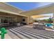 Covered patio with comfortable seating, a dining area, and seamless access to a pool, ideal for relaxation at 11181 Luna Blanca Dr, Las Vegas, NV 89138