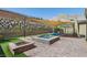 Inviting pool and spa area with a shade sail and outdoor kitchen, set against a scenic mountain backdrop at 11181 Luna Blanca Dr, Las Vegas, NV 89138