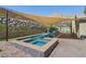 Inviting pool and spa area with a shade sail and outdoor kitchen, set against a scenic mountain backdrop at 11181 Luna Blanca Dr, Las Vegas, NV 89138