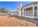 Backyard with gravel landscaping, covered patio, and view of the house at 1209 Shifting Sands Dr, Las Vegas, NV 89108