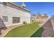 Back exterior featuring artificial turf, gravel landscaping, and a covered patio area at 1209 Shifting Sands Dr, Las Vegas, NV 89108