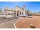 Backyard view with covered patio, gravel, stump feature, and view of home's exterior at 1209 Shifting Sands Dr, Las Vegas, NV 89108