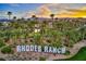Beautiful Rhodes Ranch entrance featuring lush landscaping, palm trees and a golf course at 141 Fox Lake Ave, Las Vegas, NV 89148
