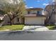 Inviting home featuring a two-car garage and a well-maintained front lawn with mature tree at 141 Fox Lake Ave, Las Vegas, NV 89148