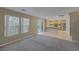Open-concept living space with plush carpet, kitchen view and access to the backyard at 141 Fox Lake Ave, Las Vegas, NV 89148