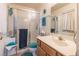 Well-lit bathroom featuring a glass shower, wood-finished vanity, and coordinated blue towels at 1892 Maricopa Dr, Laughlin, NV 89029
