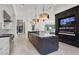 A modern kitchen featuring a large island with dark marble countertops and pendant lighting at 20 Pebble Hills Ct, Las Vegas, NV 89141