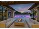 Beautiful outdoor patio features comfortable seating, modern fire pit, and a gorgeous swimming pool at dusk at 20 Pebble Hills Ct, Las Vegas, NV 89141