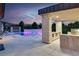 Stylish covered patio with stone pillars overlooking the pool with bar seating and built in outdoor grill at 20 Pebble Hills Ct, Las Vegas, NV 89141