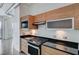 Modern kitchen with wood cabinetry, black countertops and stainless appliances at 200 Hoover Ave # 1507, Las Vegas, NV 89101