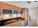 Modern kitchen with wood cabinetry, black countertops and stainless appliances at 200 Hoover Ave # 1507, Las Vegas, NV 89101