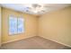 Bright bedroom with neutral walls and carpet features a ceiling fan and window at 2186 Savannah River St, Henderson, NV 89044
