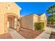 Side view of home featuring desert landscaping, brick archway, and beige exterior paint at 2186 Savannah River St, Henderson, NV 89044