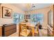 Dining area features wood floors, modern chandelier and bright window views at 2384 Yellow Bird Ct, North Las Vegas, NV 89084