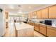 Bright kitchen boasts wood cabinets, tile floors, center island and lots of natural light at 2384 Yellow Bird Ct, North Las Vegas, NV 89084
