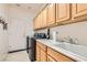 Functional laundry room with cabinets above, a utility sink, and modern washer and dryer at 2384 Yellow Bird Ct, North Las Vegas, NV 89084