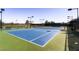 Well-maintained tennis court with vibrant blue surface and professional lighting, ideal for sports enthusiasts at 2384 Yellow Bird Ct, North Las Vegas, NV 89084