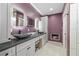 Modern bathroom with double sinks, marble countertop, and a unique glass vessel sink, featuring a cozy fireplace at 2590 Luke St, Pahrump, NV 89060