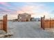 Gated home with a gravel driveway leads to a two-story home with an attached two-car garage at 2590 Luke St, Pahrump, NV 89060