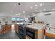 Open-concept kitchen with stainless appliances, granite countertops, an island with a cooktop and a breakfast bar at 2590 Luke St, Pahrump, NV 89060